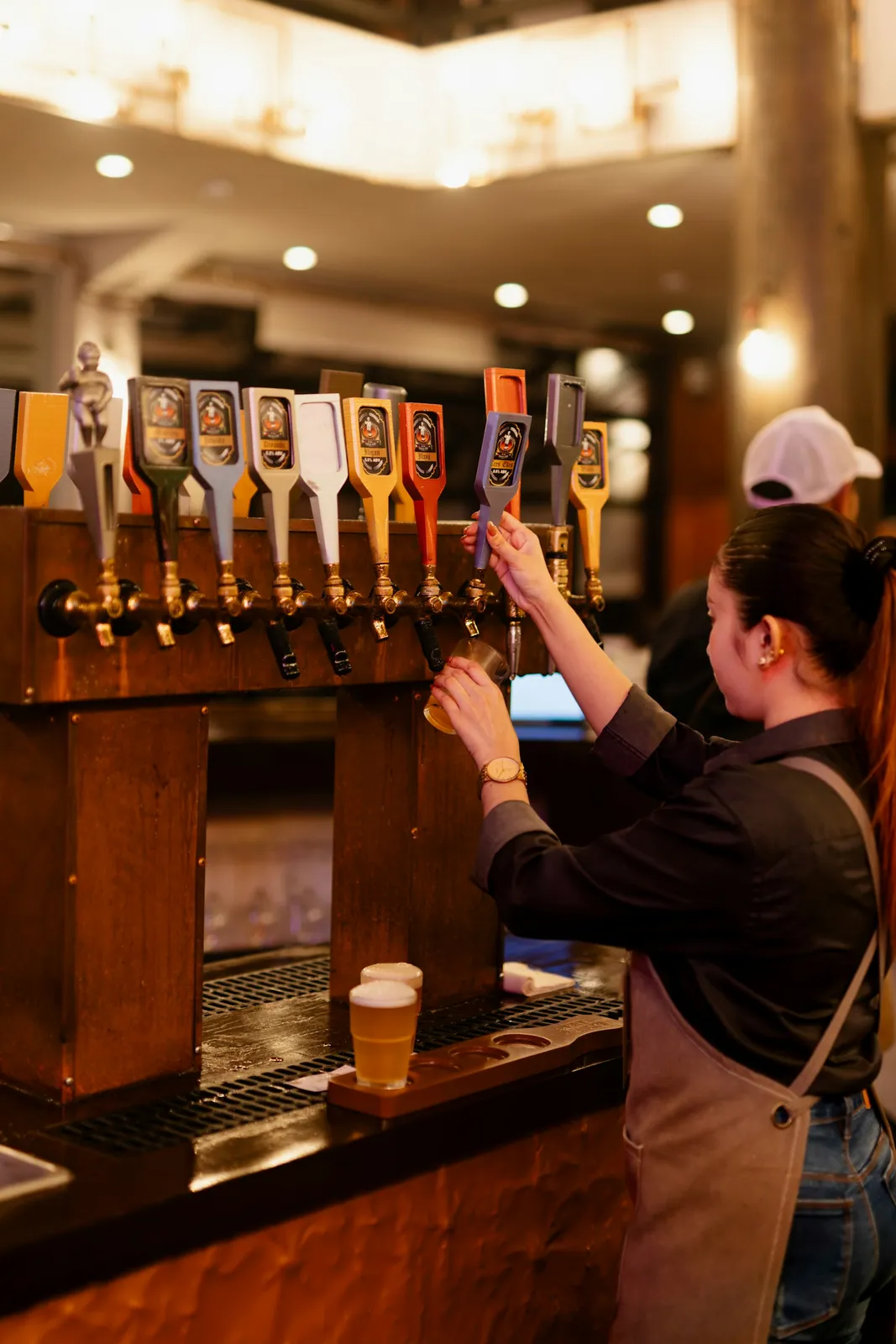 Bartender pouring from a row of draft taps