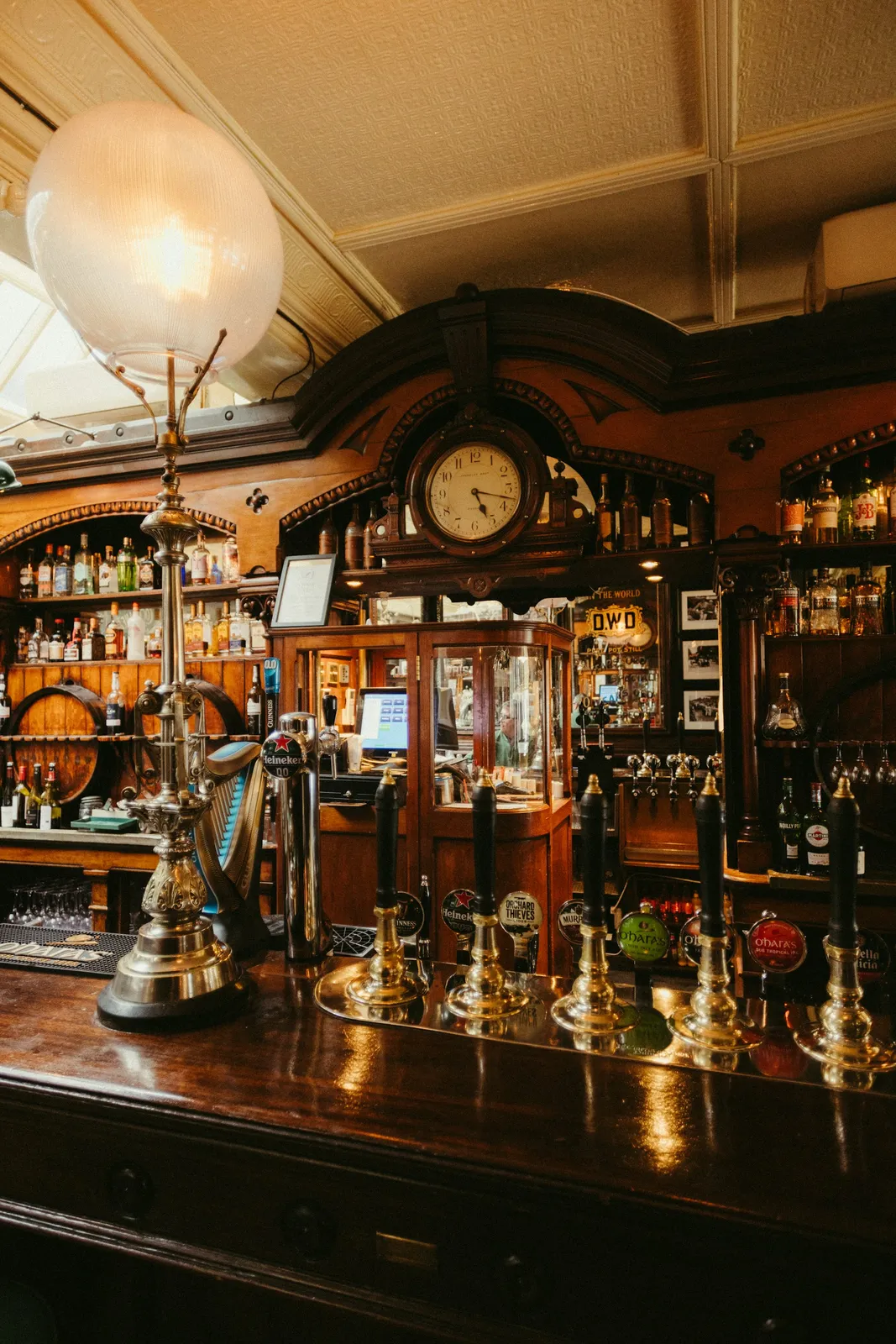 A traditional pub bar with brass taps and a wooden back bar